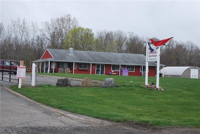 view of front of property featuring an outbuilding and a front lawn