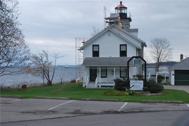 view of front of home featuring a water view, a porch, and a front yard