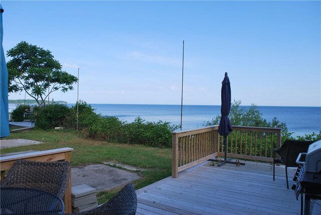 wooden deck with a water view and a yard