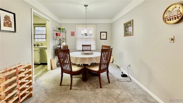 carpeted dining space featuring crown molding and a notable chandelier