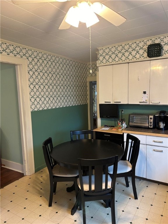 dining area with ceiling fan and ornamental molding