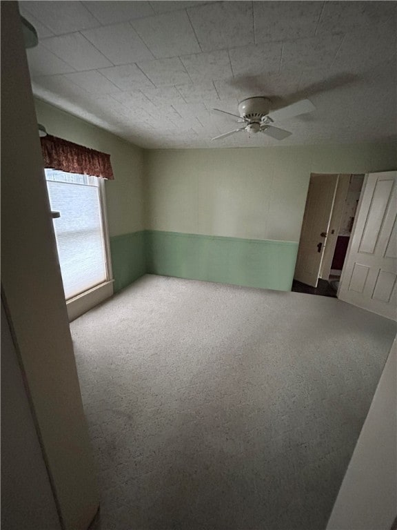 empty room with ceiling fan and carpet flooring