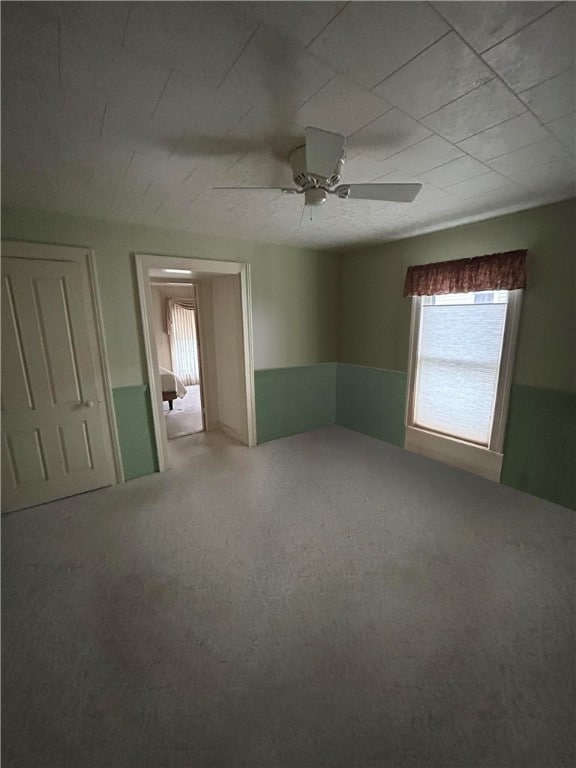 carpeted empty room featuring ceiling fan