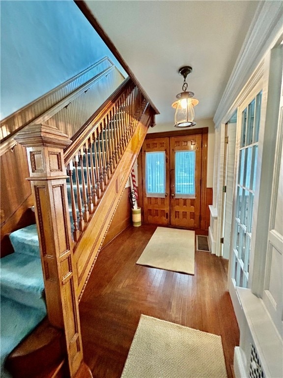 entryway featuring french doors and wood walls