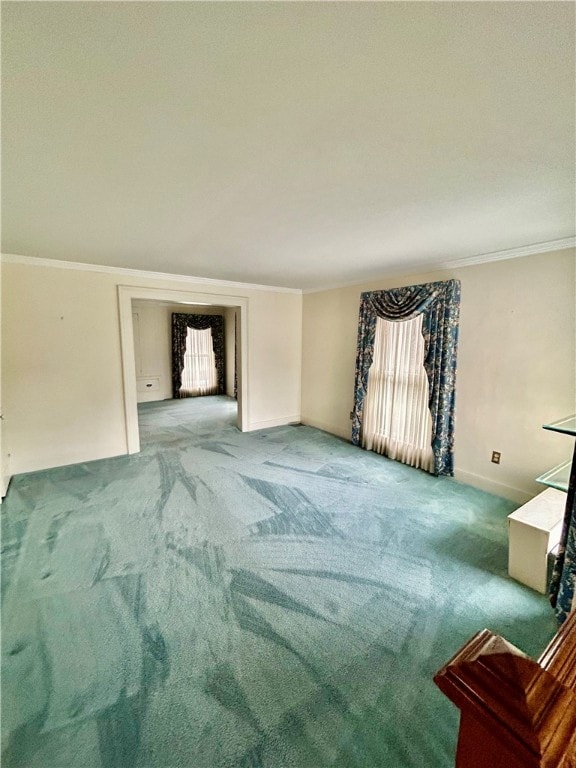 unfurnished living room with ornamental molding, carpet, and a wealth of natural light