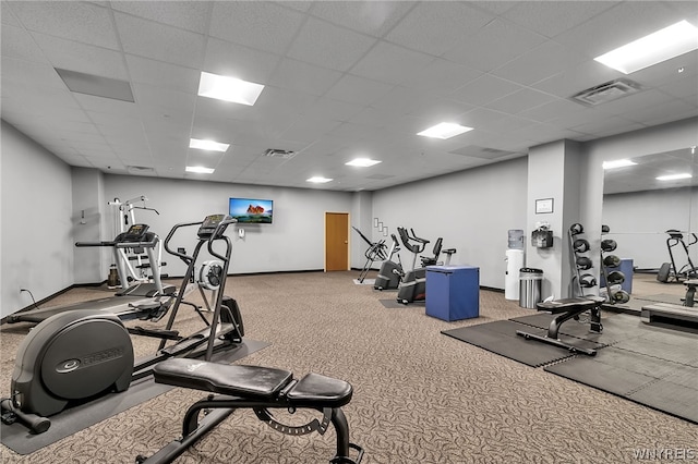 exercise room featuring light colored carpet and a paneled ceiling