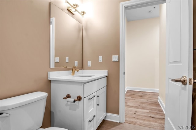 bathroom featuring wood-type flooring, toilet, and large vanity