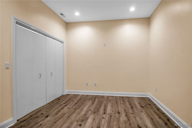 unfurnished bedroom featuring wood-type flooring and a closet