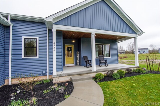 exterior space featuring covered porch and a lawn