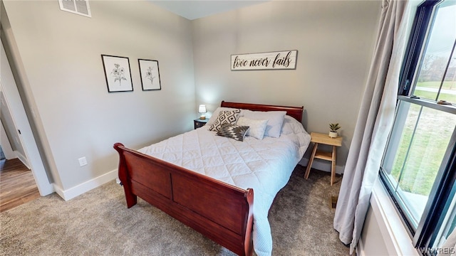 bedroom with multiple windows and carpet