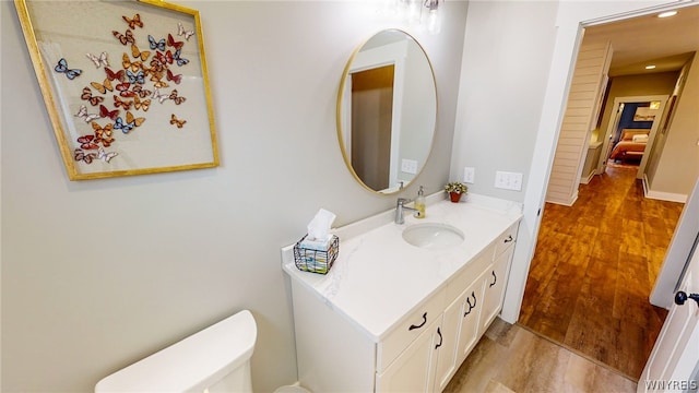 bathroom featuring toilet, hardwood / wood-style floors, and large vanity