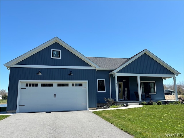 view of front of house featuring a front lawn, a garage, and a porch