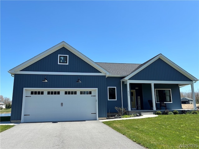 view of front facade featuring a garage, covered porch, and a front lawn