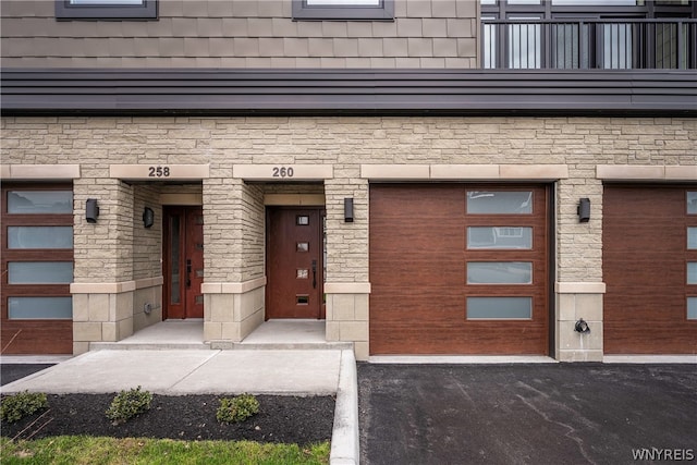 entrance to property with a garage and a balcony