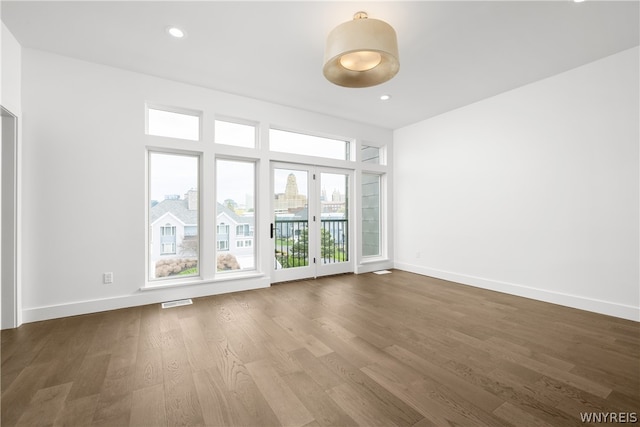 spare room with hardwood / wood-style flooring and french doors