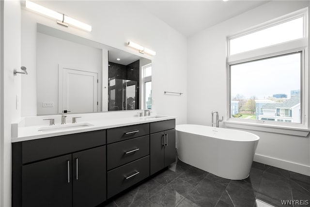 bathroom with a washtub, dual vanity, and tile floors