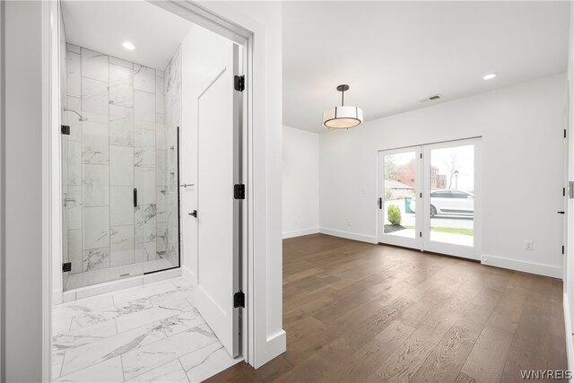 bathroom featuring hardwood / wood-style floors, french doors, and an enclosed shower