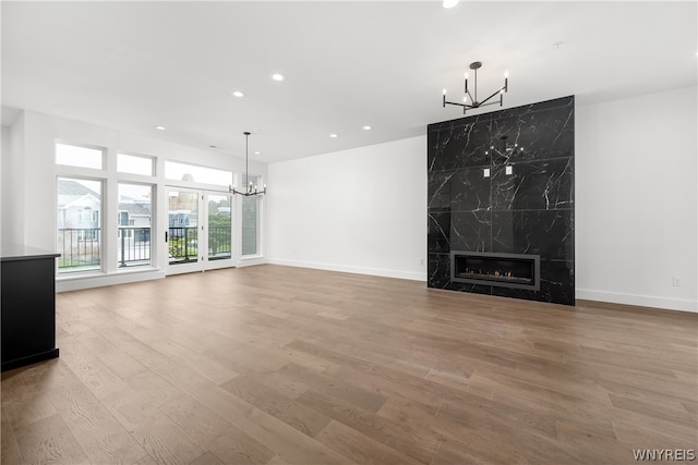 unfurnished living room with a fireplace, hardwood / wood-style floors, and a chandelier