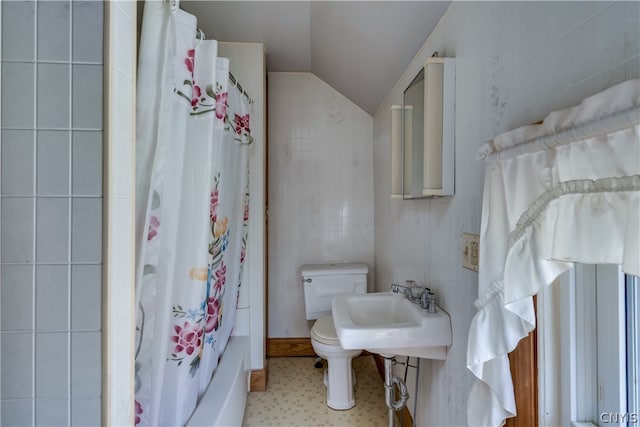 bathroom featuring tile walls, tile flooring, sink, toilet, and lofted ceiling