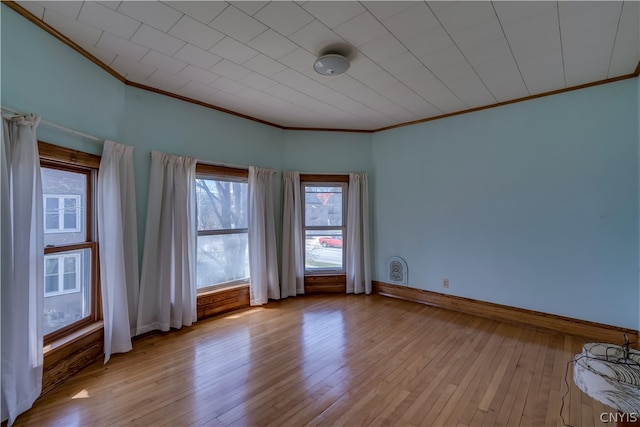 empty room with light hardwood / wood-style flooring and crown molding