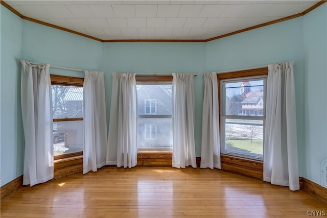 spare room with crown molding and light wood-type flooring