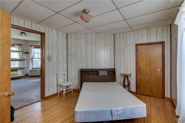 bedroom featuring a paneled ceiling and light hardwood / wood-style flooring