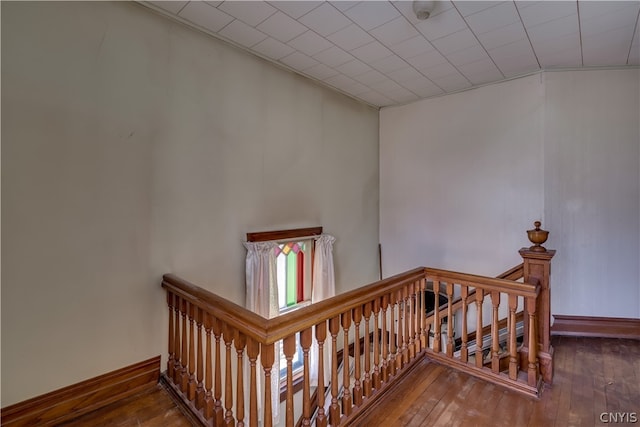 staircase with hardwood / wood-style flooring and vaulted ceiling