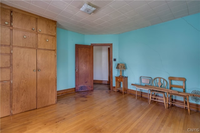 interior space with a closet, light hardwood / wood-style floors, and a paneled ceiling