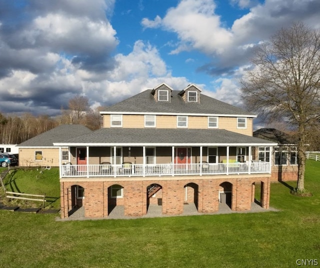 rear view of house with a balcony and a lawn