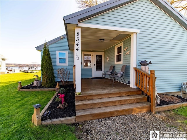 property entrance with a porch and a lawn