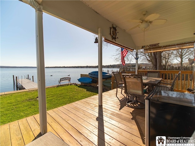 deck featuring a boat dock, a water view, and ceiling fan