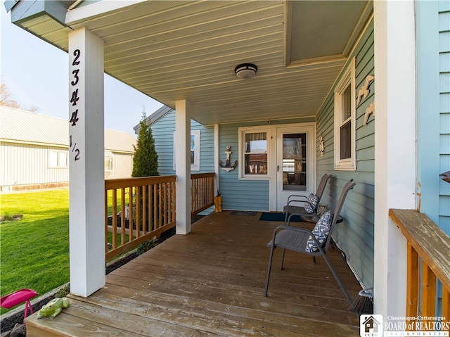 wooden deck featuring a lawn