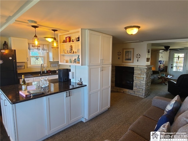 kitchen with white cabinets, plenty of natural light, and a fireplace