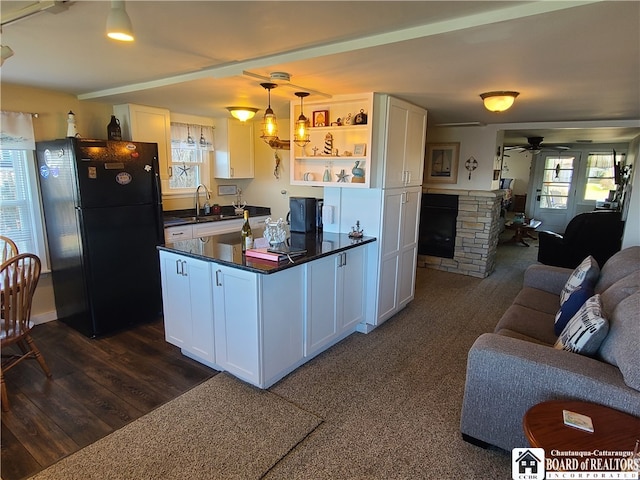 kitchen featuring white cabinets, black refrigerator, and ceiling fan