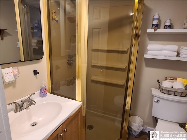 bathroom with large vanity, a shower with shower door, and toilet