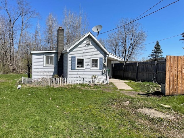 rear view of property featuring a lawn