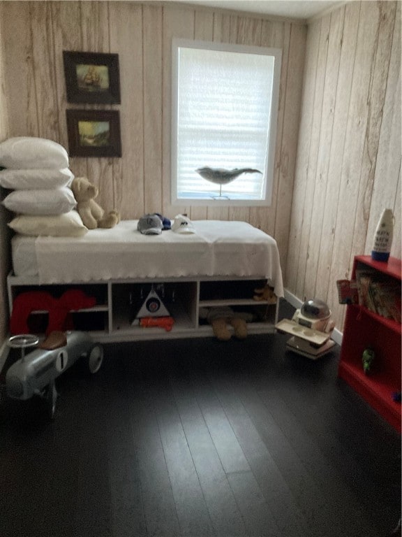 bedroom featuring wood walls and hardwood / wood-style flooring