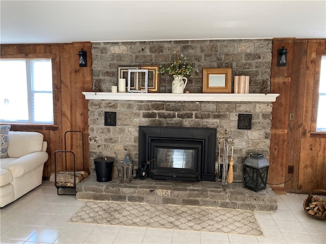 tiled living room featuring a brick fireplace and wooden walls