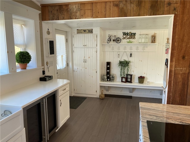 kitchen with white cabinetry, dark hardwood / wood-style flooring, and wooden walls