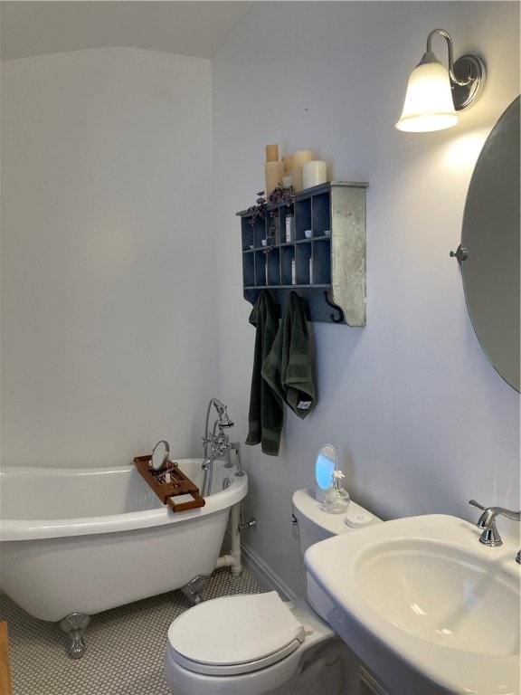 bathroom with a tub, toilet, sink, and tile patterned floors