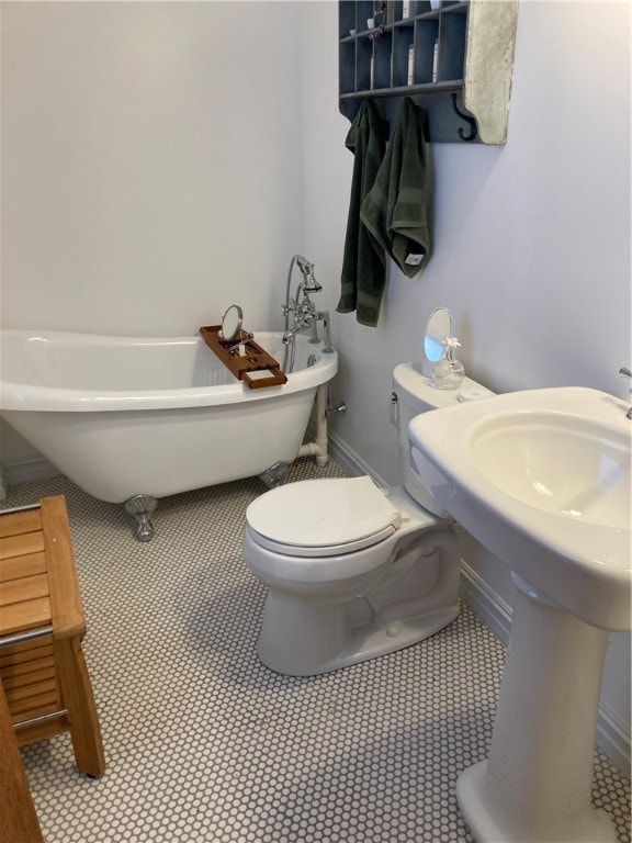 bathroom featuring toilet, tile patterned flooring, sink, and a washtub