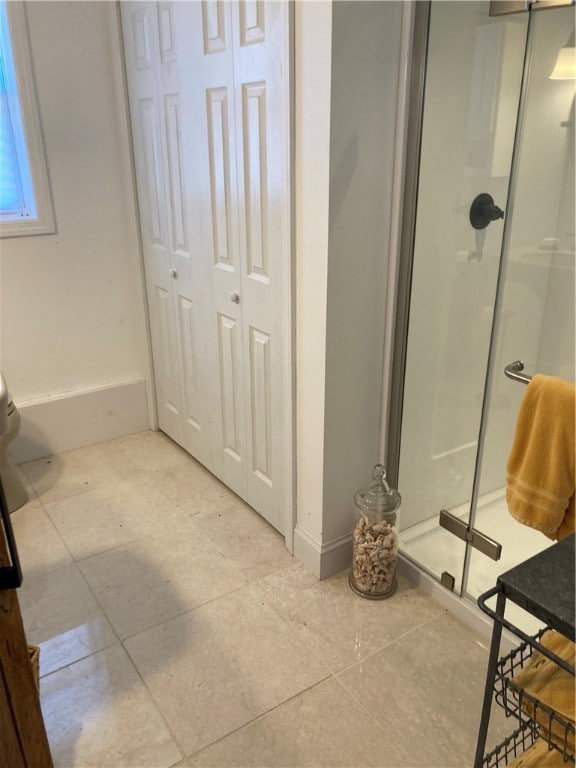 bathroom featuring tile patterned flooring and a shower with shower door