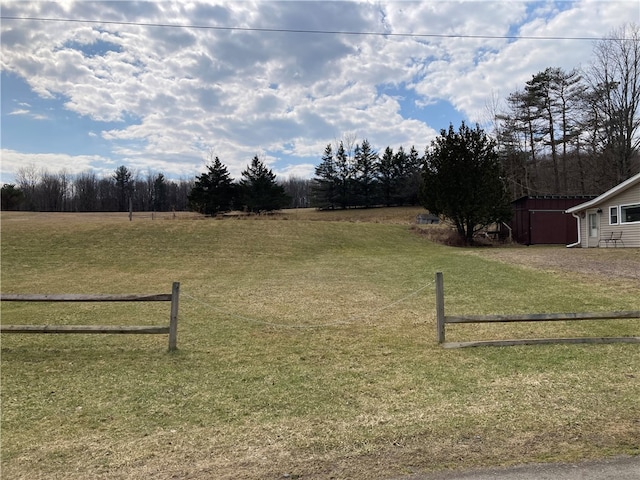 view of yard with an outbuilding and a rural view