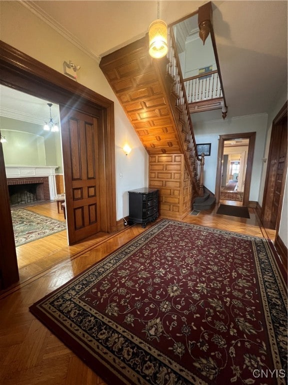 interior space featuring a brick fireplace, parquet flooring, and a chandelier