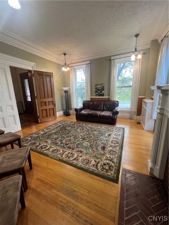 living room featuring ceiling fan, crown molding, hardwood / wood-style floors, and a healthy amount of sunlight