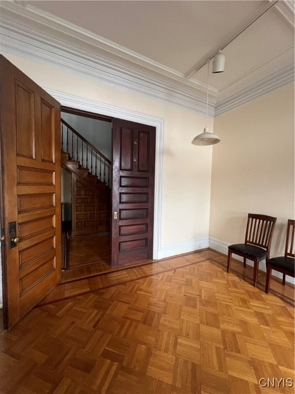 unfurnished room with light parquet floors, rail lighting, and ornamental molding