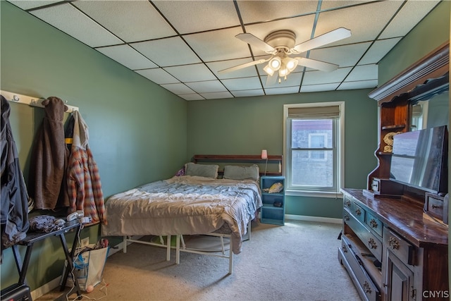 carpeted bedroom featuring a drop ceiling and ceiling fan
