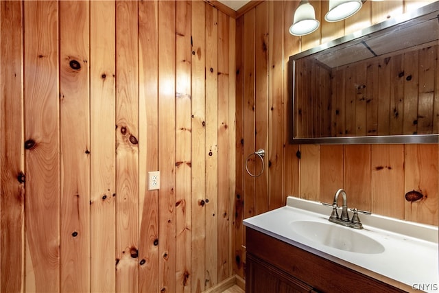 bathroom featuring vanity and wood walls
