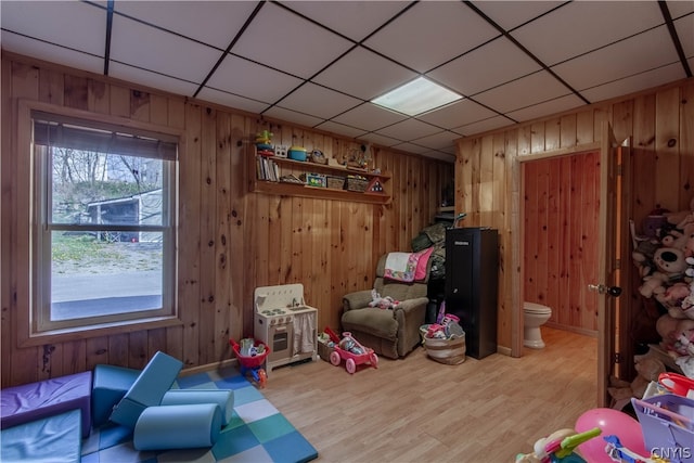 rec room featuring wood walls and light hardwood / wood-style floors