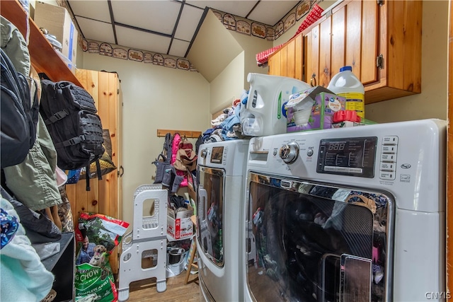 clothes washing area featuring washer and clothes dryer and cabinets